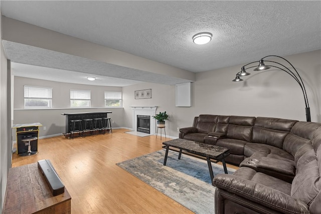509 Cresthaven Dr, Plum Boro, PA 15239 - living room with wood finished floors, a fireplace with flush hearth, and a textured ceiling
