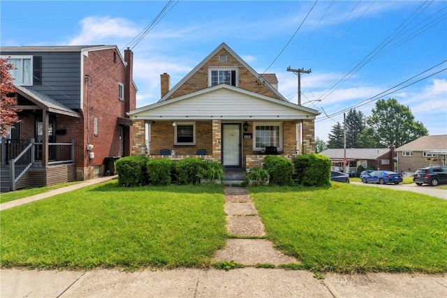 439 Ford St, West Mifflin, PA 15122 - bungalow featuring covered porch, brick siding, and a front yard