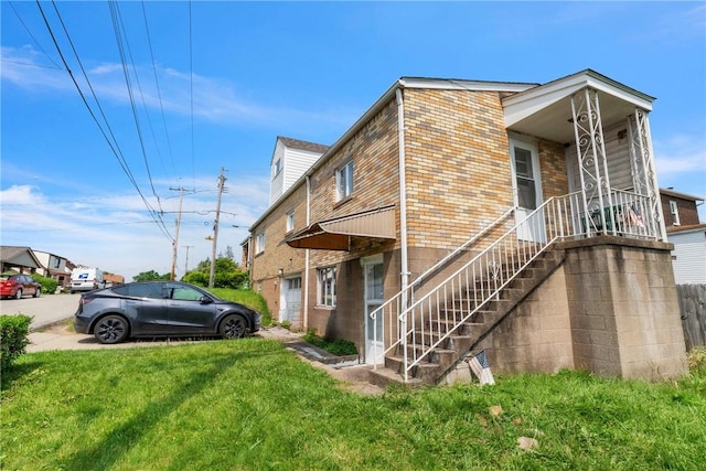 439 Ford St, West Mifflin, PA 15122 - view of property exterior featuring brick siding, a yard, and stairway