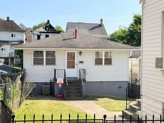 22 Lemon St, Uniontown, PA 15401 - rear view of house featuring a shingled roof and central air condition unit