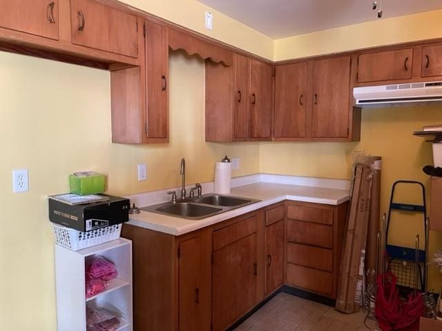 22 Lemon St, Uniontown, PA 15401 - kitchen featuring a sink, light countertops, under cabinet range hood, and brown cabinetry