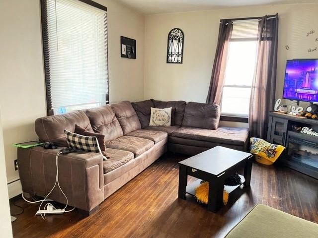 22 Lemon St, Uniontown, PA 15401 - living room with wood finished floors and a baseboard radiator
