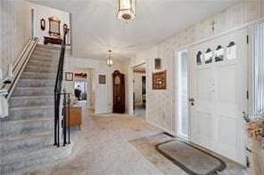 229 Crawford Ln, Rostraver, PA 15012 - carpeted foyer with stairs and wallpapered walls