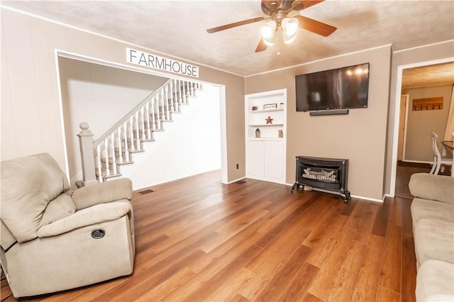 198 Gastown Rd, Plumcreek Twp, PA 15774 - living area featuring a wood stove, ceiling fan, wood finished floors, stairway, and built in shelves