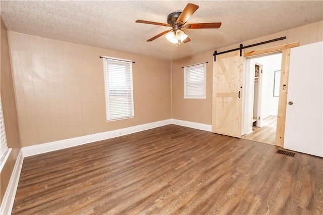 198 Gastown Rd, Plumcreek Twp, PA 15774 - unfurnished room with a barn door, a ceiling fan, wood finished floors, a textured ceiling, and baseboards