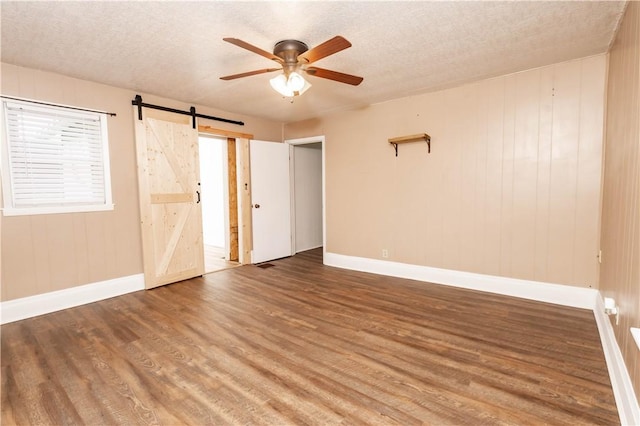 198 Gastown Rd, Plumcreek Twp, PA 15774 - spare room with baseboards, a ceiling fan, wood finished floors, a barn door, and a textured ceiling