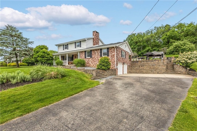 375 Navaho Hollow Rd, Coolbaugh Twp, PA 15438 - view of front of home featuring a chimney, a front yard, an attached garage, covered porch, and driveway