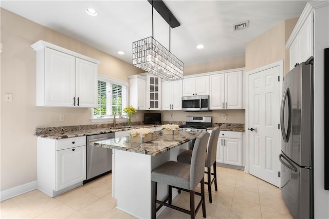 8007 Pressley Ct, Mccandless, PA 15237 - kitchen featuring stainless steel appliances, white cabinets, a breakfast bar, stone countertops, and a center island
