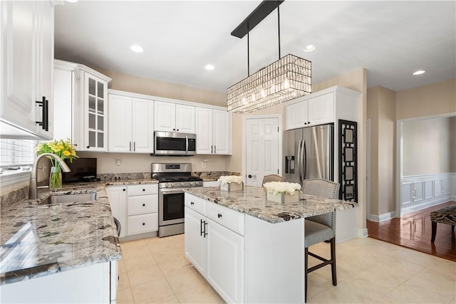 8007 Pressley Ct, Mccandless, PA 15237 - kitchen featuring stainless steel appliances, a sink, a kitchen bar, a center island, and white cabinetry
