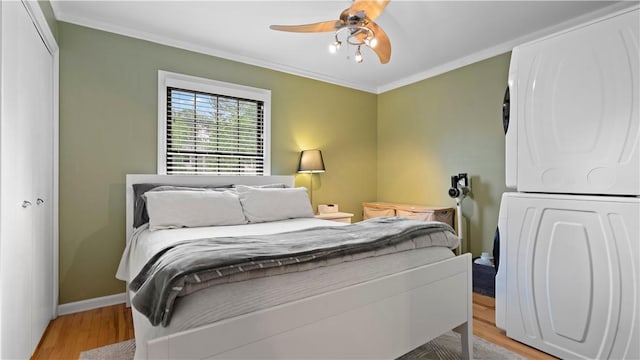 718 Carriage Cir, Pennsbury, PA 15205 - bedroom featuring stacked washing machine and dryer, wood finished floors, crown molding, baseboards, and a ceiling fan
