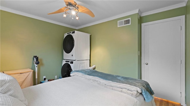 718 Carriage Cir, Pennsbury, PA 15205 - bedroom with stacked washing machine and dryer, ornamental molding, wood finished floors, and ceiling fan
