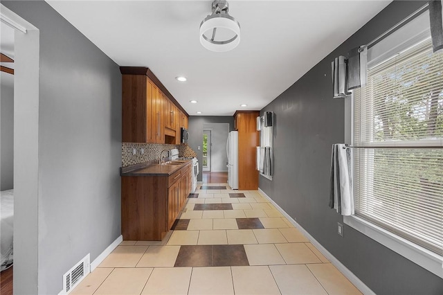 2001 Potomac Ave, Banksville/Westwood, PA 15216 - kitchen featuring a sink, stove, freestanding refrigerator, brown cabinets, and tasteful backsplash