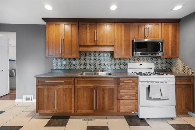 2001 Potomac Ave, Banksville/Westwood, PA 15216 - kitchen featuring stainless steel microwave, gas range gas stove, a sink, dark countertops, and brown cabinetry