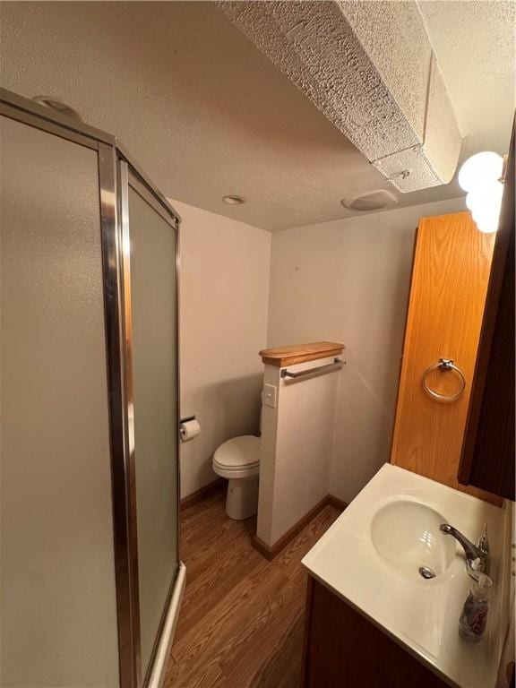 661 Johnston Ave, Kittanning Boro, PA 16201 - bathroom featuring a shower stall, wood finished floors, toilet, vanity, and a textured ceiling
