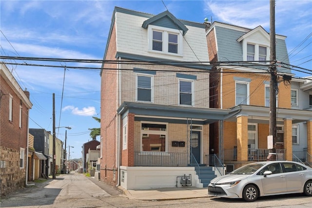 130 Pearl St, Bloomfield, PA 15224 - townhome / multi-family property featuring brick siding, a porch, and a residential view