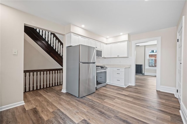 130 Pearl St, Bloomfield, PA 15224 - kitchen with stainless steel appliances, white cabinetry, light wood finished floors, and recessed lighting