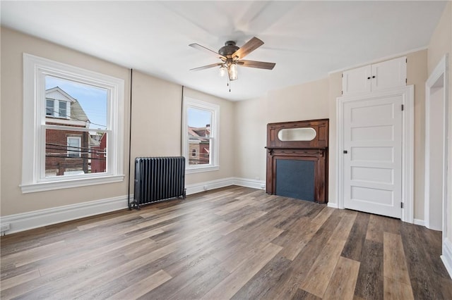 130 Pearl St, Bloomfield, PA 15224 - unfurnished living room with radiator, wood finished floors, ceiling fan, and baseboards