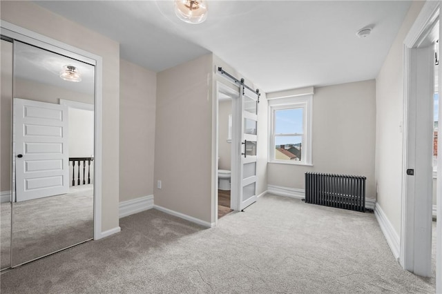 130 Pearl St, Bloomfield, PA 15224 - unfurnished bedroom featuring radiator heating unit, a barn door, carpet, and baseboards