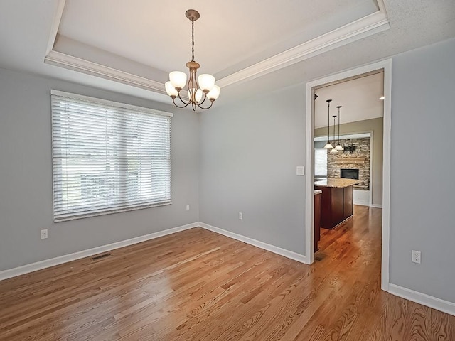 430 Longleaf Dr, Peters Twp, PA 15367 - unfurnished room with a tray ceiling, a chandelier, a fireplace, wood finished floors, and baseboards