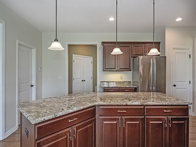 430 Longleaf Dr, Peters Twp, PA 15367 - kitchen featuring freestanding refrigerator, dark wood-style flooring, a kitchen island, decorative light fixtures, and light stone counters