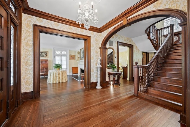 700 Meade St, Monongahela, PA 15063 - foyer featuring wallpapered walls, hardwood / wood-style flooring, arched walkways, stairs, and a chandelier