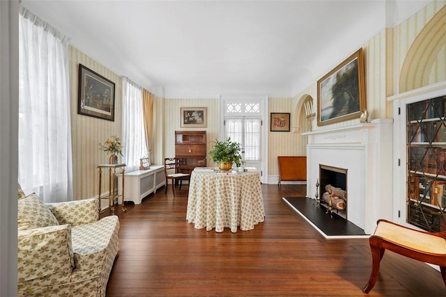 700 Meade St, Monongahela, PA 15063 - living area featuring wallpapered walls, a fireplace with raised hearth, dark wood-type flooring, and baseboards