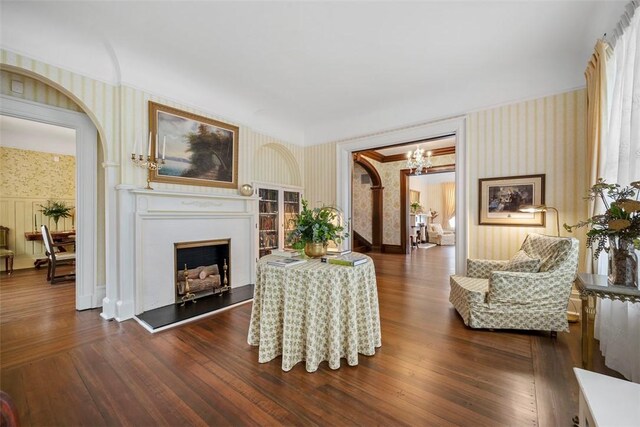 700 Meade St, Monongahela, PA 15063 - living area with wallpapered walls, a chandelier, a fireplace with raised hearth, arched walkways, and dark wood-type flooring