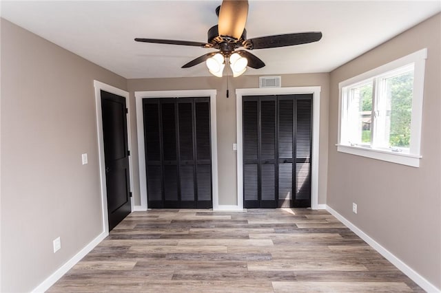 200 Centerwood Cir, South Union Twp, PA 15401 - unfurnished bedroom featuring two closets, light wood-style flooring, baseboards, and ceiling fan