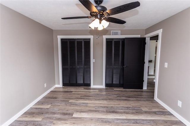 200 Centerwood Cir, South Union Twp, PA 15401 - unfurnished bedroom featuring two closets, wood finished floors, baseboards, and ceiling fan