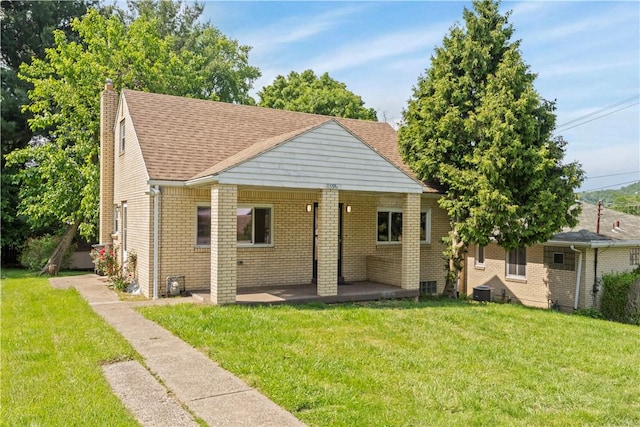 2396 Foster Rd, White Oak, PA 15131 - view of front of house featuring a chimney, a patio, a front yard, and brick siding