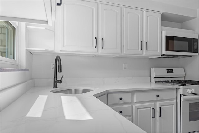 2396 Foster Rd, White Oak, PA 15131 - kitchen featuring white gas range, white cabinets, and a sink