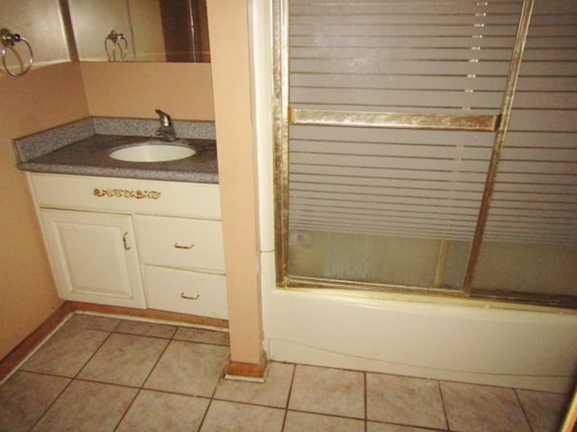 945 Roup Ave, Brackenridge, PA 15014 - bathroom with combined bath / shower with glass door, vanity, tile patterned flooring, and baseboards