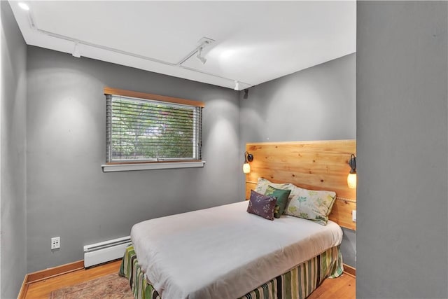 326 Pinevue Dr, Monroeville, PA 15146 - bedroom with a baseboard radiator, track lighting, wood finished floors, and baseboards