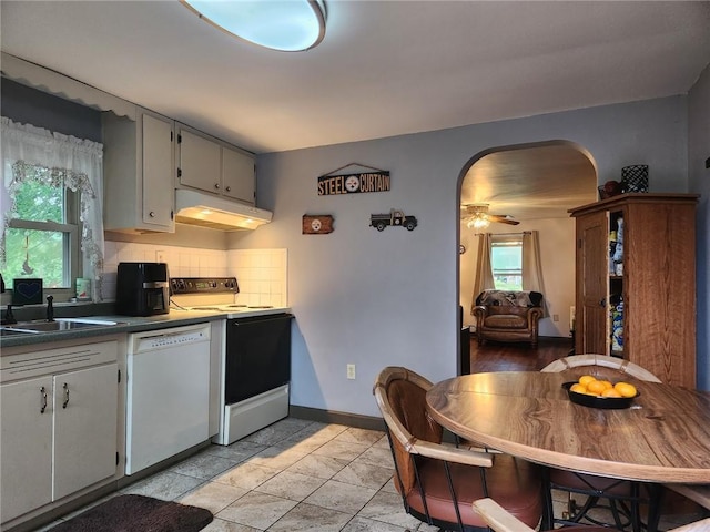 145 7th St, E Butler Boro, PA 16029 - kitchen featuring electric range, white dishwasher, under cabinet range hood, arched walkways, and tasteful backsplash
