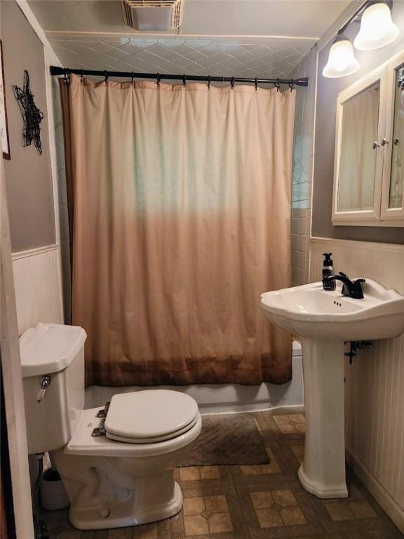 145 7th St, E Butler Boro, PA 16029 - bathroom featuring shower / tub combo with curtain and a wainscoted wall