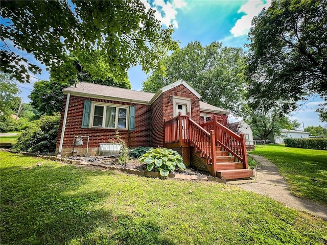 145 7th St, E Butler Boro, PA 16029 - view of front of property with brick siding, a front yard, and roof with shingles