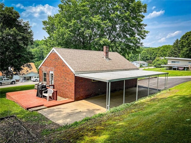 145 7th St, E Butler Boro, PA 16029 - view of side of property featuring brick siding, a deck, a lawn, a chimney, and a shingled roof