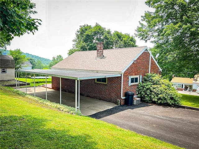145 7th St, E Butler Boro, PA 16029 - view of property exterior with brick siding, a yard, roof with shingles, and a chimney