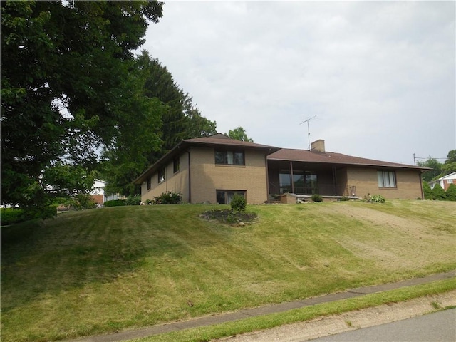 1118 Fairlane Dr, Hopewell Twp Bea, PA 15001 - view of front facade featuring brick siding, a chimney, and a front lawn