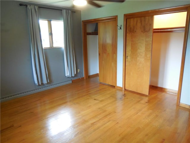 1118 Fairlane Dr, Hopewell Twp Bea, PA 15001 - unfurnished bedroom featuring multiple closets, baseboard heating, light wood-type flooring, a ceiling fan, and baseboards
