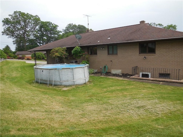 1118 Fairlane Dr, Hopewell Twp Bea, PA 15001 - back of property with brick siding, a yard, an outdoor pool, roof with shingles, and a chimney