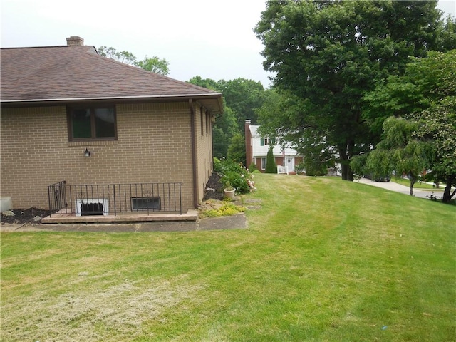 1118 Fairlane Dr, Hopewell Twp Bea, PA 15001 - view of home's exterior featuring roof with shingles, a yard, brick siding, and central AC