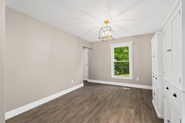 14 Laurel Hill Rd, Cecil, PA 15057 - unfurnished dining area with a chandelier, dark wood finished floors, baseboards, and a textured ceiling