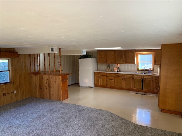 1464 State Route 819, Salem Twp Wml, PA 15601 - kitchen featuring freestanding refrigerator, a sink, brown cabinetry, wood walls, and light countertops