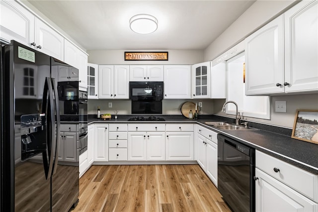 11660 Dennis Cir N, Huntingdon, PA 15642 - kitchen featuring black appliances, a sink, light wood-type flooring, dark countertops, and white cabinets