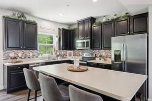 139 Moyer Hl, Cranberry Twp, PA 16066 - kitchen featuring appliances with stainless steel finishes, a center island, a kitchen bar, tasteful backsplash, and recessed lighting