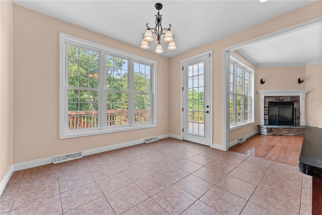621 Columbia Ct, Adams Twp, PA 16046 - unfurnished dining area with healthy amount of natural light, a chandelier, tile patterned floors, a stone fireplace, and crown molding