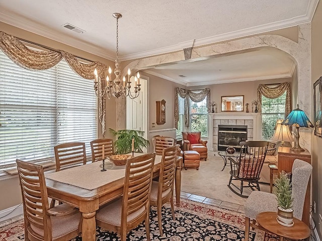 210 Adams Pointe Blvd Unit 6, Adams Twp, PA 16046 - dining room featuring a chandelier, crown molding, a tile fireplace, a textured ceiling, and light carpet