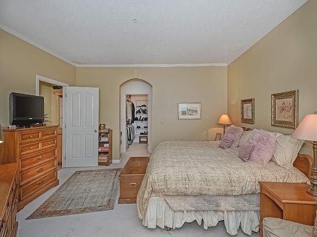 210 Adams Pointe Blvd Unit 6, Adams Twp, PA 16046 - carpeted bedroom featuring crown molding, a textured ceiling, arched walkways, a walk in closet, and a closet