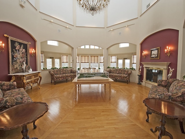 210 Adams Pointe Blvd Unit 6, Adams Twp, PA 16046 - living area featuring plenty of natural light, a high ceiling, a glass covered fireplace, and light wood-type flooring